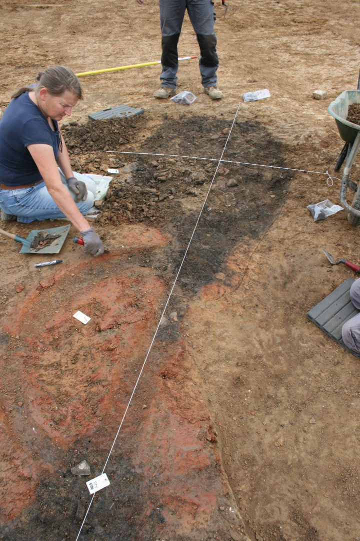  les alandiers sont noirs car charbonneux. Le four ressort par la rubéfaction (de couleur rouge/orange). On perçoit le canal central et la rigole périphérique qui donne un dessin « en grain de café ». 