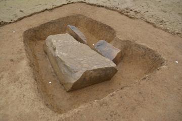 Vue des trois blocs  en cours de fouille, dont la stèle face décorée contre le sol.