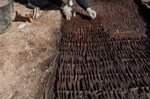 Dégagement des vanneries des cuves de tannage (XIVe-XVe s.), fouille du site de l'Hôtel du Département à Troyes (Aube), 2010.  Au contact avec le tanin de l'écorce de chêne, utilisée pour traiter les peaux, les ouvrages en vannerie de ces bassins se sont 