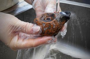 Lampe &agrave; huile en cours de nettoyage, port antique d'Antibes (Alpes-Maritimes), 2012.